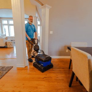 Technician cleaning a hardwood floor with a floor scrubber